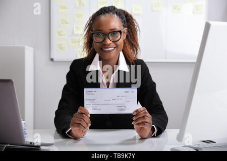 Close-up Of A Smiling Businesswoman Showing Company Cheque Stock Photo