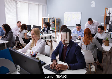 Group Of Multi-ethnic Businesspeople Working On Computer In Office Stock Photo