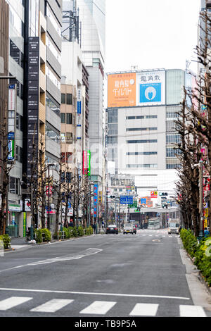 Tokyo, Japan - March 30, 2019: Shinjuku empty road street by buildings in modern city on cloudy day Stock Photo