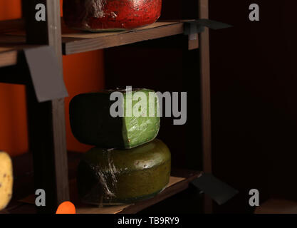 Assortment of tasty cheese on shelves in store Stock Photo