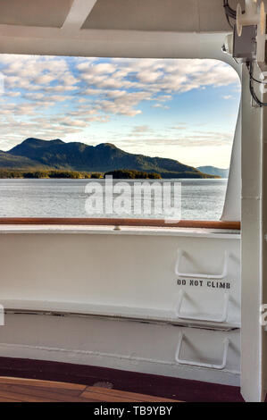 Metal ladder rungs on cruise ship deck with words 'do not climb', and view of mountain scenery in background, Inside Passage, near Ketchikan, Alaska. Stock Photo