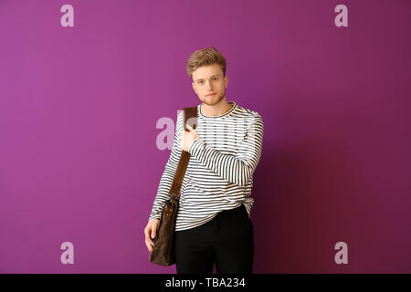 Handsome man with stylish briefcase on color background Stock Photo
