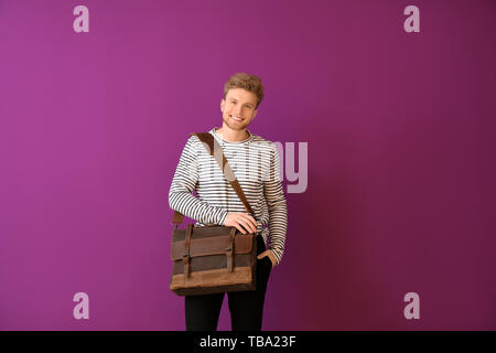 Handsome man with stylish briefcase on color background Stock Photo