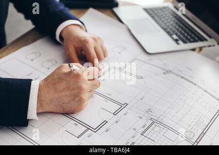 Mature architect working with drawings in office, closeup Stock Photo
