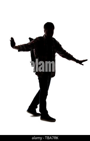 Silhouette of a male tour guide hiking and carrying a backpack on a white background.  He is carefully gesturing stop.  Depicts adventure and explorat Stock Photo