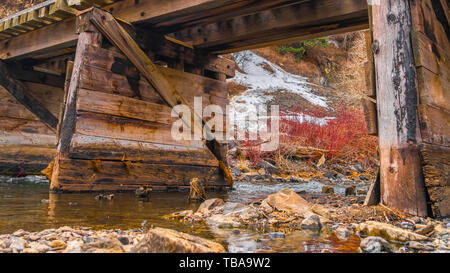 frame Panorama frame Rustic wooden bridge crossing over a rocky stream with clear shallow water Stock Photo