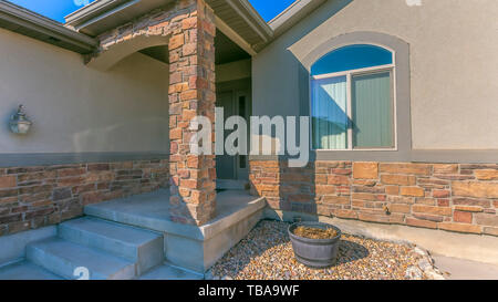 frame Panorama Facade of a home with a rocky yard and small front porch Stock Photo