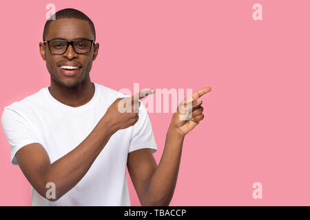 Handsome man in glasses looking at camera pointing aside Stock Photo