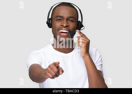Smiling african man in headset looking pointing finger at camera Stock Photo