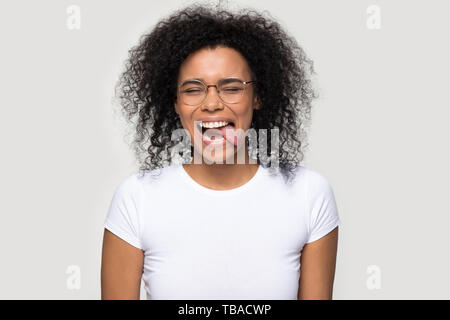 Funny attractive african woman showing tongue studio head shot portrait Stock Photo