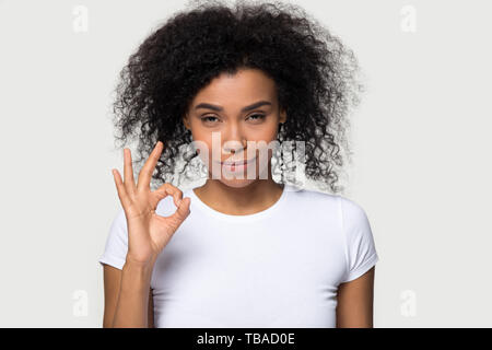 Happy african female showing ok sign pose over gray blank Stock Photo