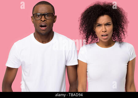 Shocked african couple looking at camera posing in studio Stock Photo