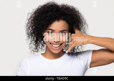 Happy mixed race woman makes call me gesture with hand Stock Photo