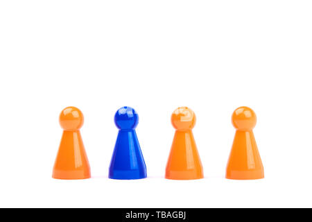 A series of orange game pieces and one different and exceptional blue figure as leader or boss - isolated on a white background Stock Photo