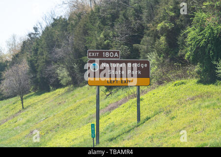 Lexington, USA - April 18, 2018: Sign for Natural Bridge State Park left exit 180A on Virginia street road highway and green trees Stock Photo