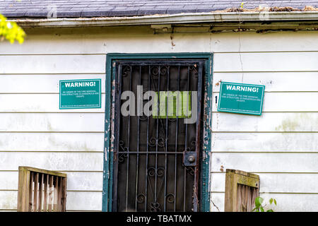 Atlanta, USA - April 21, 2018: Old abandoned house in Georgia with entrance door and notice sign warning from fire marshal Stock Photo