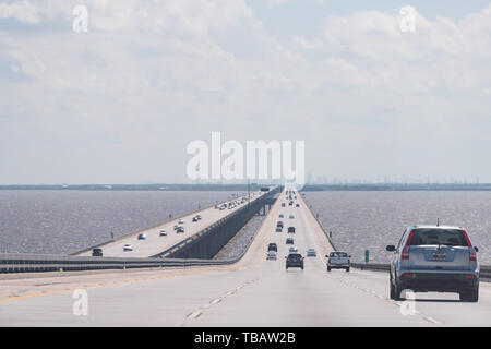 Slidell, USA - April 22, 2018: Highway road long bridge with traffic to New Orleans with view of cityscape skyline on horizon and cars