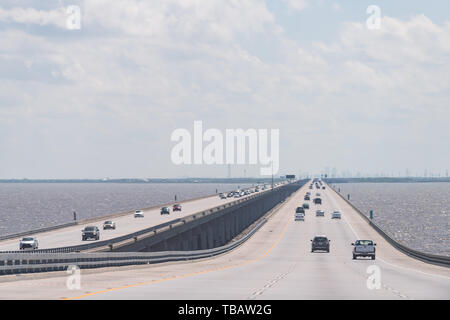 Slidell, USA - April 22, 2018: Highway road i10 long bridge with traffic to New Orleans with view of cityscape skyline on horizon and cars Stock Photo