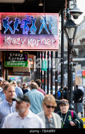 New Orleans, USA - April 23, 2018: Louisiana famous city with many people crowd walking on Bourbon street with Krazy Korner neon sign Stock Photo