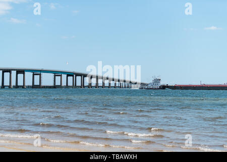 Navarre, USA - April 24, 2018: Towboat or tugboat towing tank barge boat ship vessel in Pensacola bay near sea ocean shore of Gulf of Mexico, Florida  Stock Photo