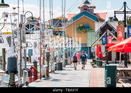 Destin, USA - April 24, 2018: Harborwalk village, people walking by marina with Margaritaville restaurant tropical bar cafe on summer sunny day in Flo Stock Photo