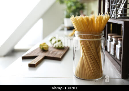 Dry pasta in glass jar on counter in kitchen Stock Photo