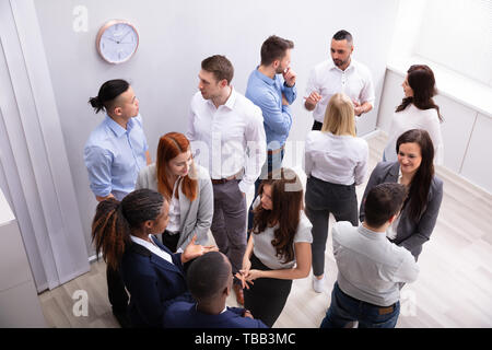 Professional Diverse Businesspeople Discussing With Each Other In Corporate Office Stock Photo