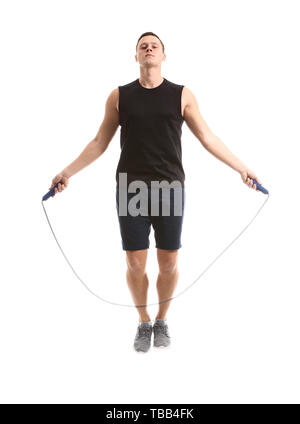 Sporty young man jumping rope against white background Stock Photo