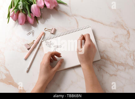 Female hands with stationery on light background Stock Photo