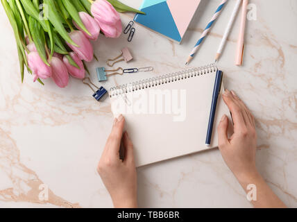 Female hands with stationery on light background Stock Photo