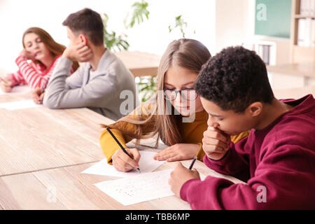 Girl cheating during school test in classroom Stock Photo