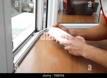 Young worker installing window in flat Stock Photo