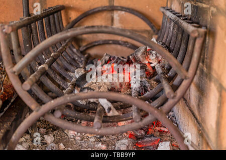 Typical Argentinian barbecue or asado. Burning wood in the grill and red hot coals Stock Photo