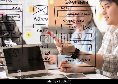 IT designers discussing project, view through transparent board Stock Photo