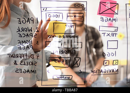 IT designers discussing project, view through transparent board Stock Photo