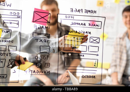 IT designers discussing project, view through transparent board Stock Photo