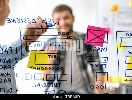 IT designers discussing project, view through transparent board Stock Photo