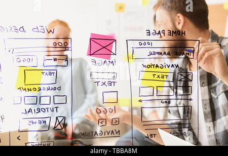 IT designers discussing project, view through transparent board Stock Photo