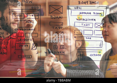 IT designers discussing project, view through transparent board Stock Photo