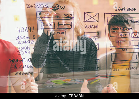 IT designers discussing project, view through transparent board Stock Photo