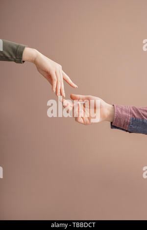 Man and woman giving each other hands on color background. Concept of support and help Stock Photo