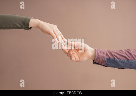 Man and woman giving each other hands on color background. Concept of support and help Stock Photo