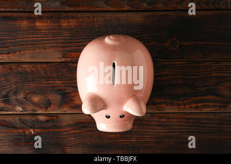 Happy piggy bank on wooden background, space for text and top view. Finance, saving money Stock Photo