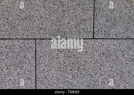The crushed stone surface of the wall, separated by squares. Close up. Grey background. Stock Photo