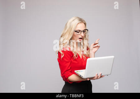 Shocked woman with open mouth keeping computer Stock Photo