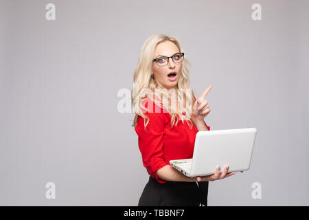 Shocked woman with open mouth keeping computer Stock Photo