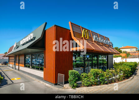 Cascais, Portugal - May 31, 2019: Outside view of facade of modern McDonald's fast-food restaurant with drive-thru on a sunny day Stock Photo