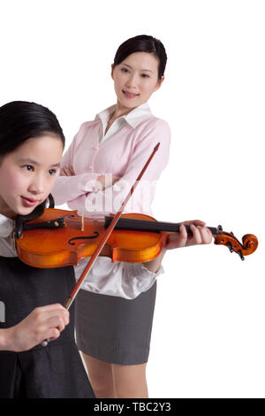 Mother urges daughter to practice violin Stock Photo