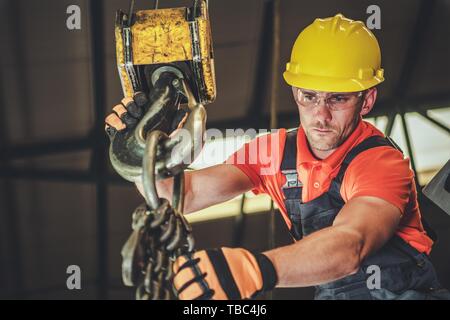 Caucasian Warehouse Lift Operator in His 30s. Heavy Duty Lifting Equipment. Stock Photo