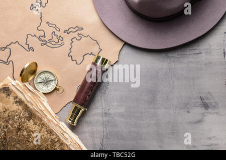 Map with compass and spyglass on grey table Stock Photo